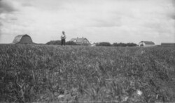 Sam J Chernoff about 1928 Section 13 Khutor Ranch. L. to R. Cow Barn, Sam, House, Bath House, Horse Barn, Implement shed. It says in Russian they lived there since 1914. (saskatchewan) Sam J Chernoff