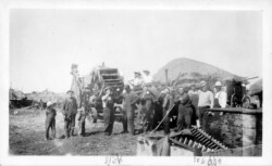 1935. Lunch time after threshing done. Pile in back - straw. Nick appointed lead and operated the threshing machine. Nick in middle. Threshing Time