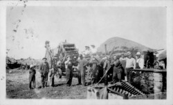 1935. Lunch time after threshing done. Pile in back - straw. Nick appointed lead and operated the threshing machine. Nick in middle. Lunch TIme